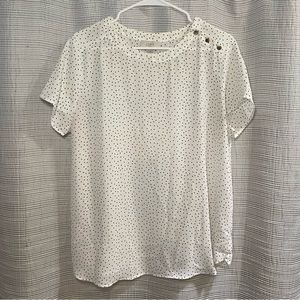 White blouse with black polka dots and faux brass buttons on the left shoulder